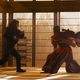 Matrix Resurrections' Morpheus and Neo fighting in the dojo.